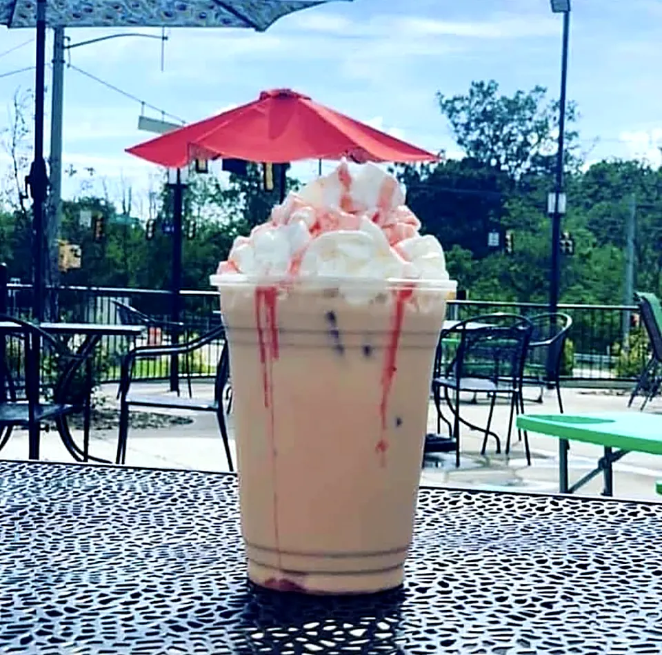 A strawberry freeze piled with whipped cream on the patio